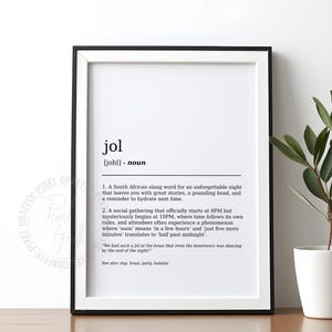 Puede incluir: Un marco negro con un paspartú blanco que contiene una impresión con la palabra "jol" y su definición en negro. A la derecha hay una pequeña maceta con hojas verdes.