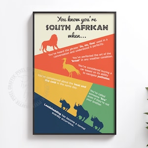 May include: A framed poster titled You know you're SOUTH AFRICAN when... featuring colourful diagonal sections with silhouettes of a lion, bird, and rhinos. The text lists cultural phrases and experiences including braai, potholes, and loadshedding.