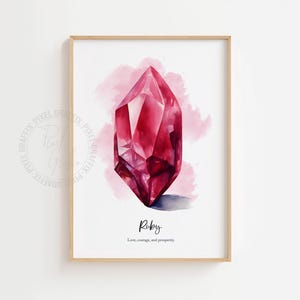 Könnte beinhalten: Ein gerahmter Druck mit einer Aquarellillustration eines Rubinkristalls. Das Kunstwerk zeigt einen leuchtenden, facettierten roten Edelstein vor einem weichen rosa Aquarellhintergrund. Das Wort "Ruby" steht darunter, zusammen mit den Worten "Liebe, Mut und Wohlstand."