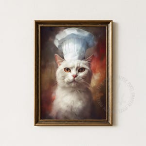 May include: A framed art print featuring a white cat wearing a chef's hat. The cat has orange eyes and a pink nose, set against a warm, painterly background of reds and browns. The frame is a warm gold color.