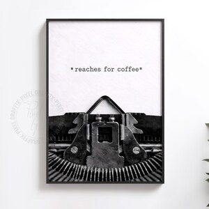 Peut inclure: Impression en noir et blanc encadrée d'une machine à écrire vintage. Le texte "* reaches for coffee *" est écrit dans une police de machine à écrire. L'image est un gros plan des touches et du mécanisme de la machine.