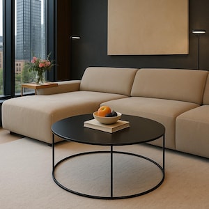 Peut inclure: Salon moderne avec un canapé sectionnel beige, une table basse ronde noire et un tapis de couleur claire. Un bol de fruits est posé sur la table. Une grande fenêtre offre une vue sur les toits de la ville.