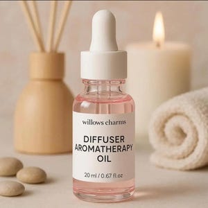 Może przedstawiać: Butelka olejku do aromaterapii z białą pipetą i różowym płynem. Etykieta głosi "willows charms" i "DIFFUSER AROMATHERAPY OIL" o pojemności 20 ml. Świeca i zwinięty ręcznik znajdują się w tle.