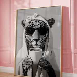 K&ouml;nnte beinhalten: Eine Schwarzwei&szlig;illustration eines Leoparden mit Sonnenbrille und Handtuch, der eine wei&szlig;e Kaffeetasse h&auml;lt.