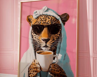 May include: A framed wall art print featuring a leopard wearing black sunglasses and a white towel wrapped around its head and shoulders. The leopard is holding a white coffee mug with both paws against a solid, vibrant pink background.