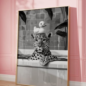 May include: A black and white photograph of a leopard in a bathtub with a rubber duck on its head. The leopard is looking directly at the camera.