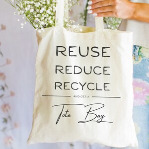 May include: A white canvas tote bag with the words "Reuse Reduce Recycle" and "And get a Tote Bag" in black text.