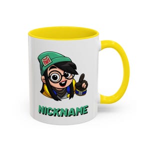 Könnte beinhalten: Weißer Keramikbecher mit gelbem Innenraum und Henkel. Der Becher zeigt eine Cartoon-Grafik eines Charakters mit Brille und grüner Mütze. Das Wort "NICKNAME" ist in grünen Buchstaben auf den Becher gedruckt.