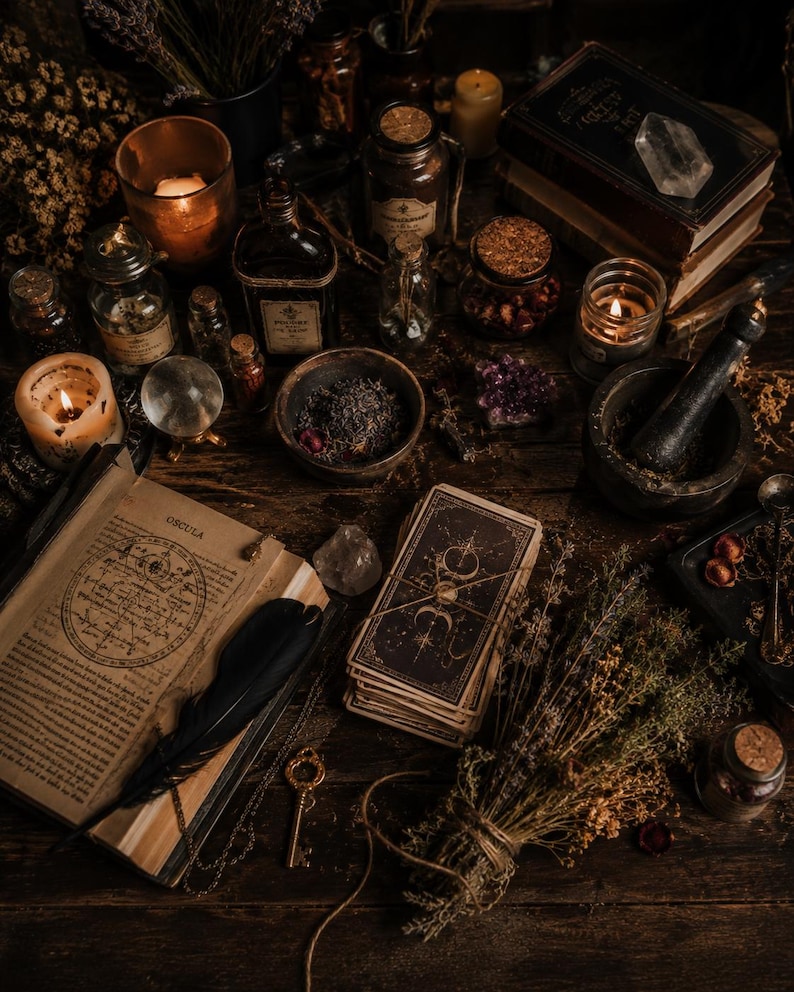 May include: A still-life arrangement of mystical items on a dark wooden surface. The scene includes lit candles, open books, tarot cards, glass bottles, a crystal ball, dried herbs, and a mortar and pestle. The overall color palette is warm, with shades of brown and gold.