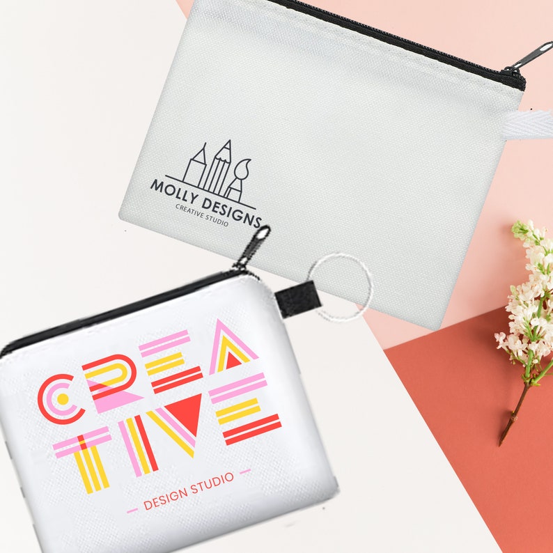 May include: Two white zippered pouches with different designs. The first pouch has a black and white logo that says "Molly Designs Creative Studio". The second pouch has a colourful geometric design that says "Creative - Design Studio".