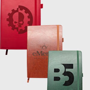 May include: Three rectangular notebooks with elastic closures and pen loops. The top left is red with a skull and gear graphic. The middle is brown with a sun icon and the text eMer. The bottom right is green with the large black text B5.