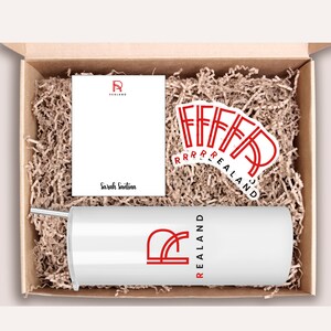 Peut inclure: Une bo&icirc;te cadeau blanche remplie de papier d'emballage brun. La bo&icirc;te contient un gobelet blanc avec un logo rouge qui dit "REALAND". Il y a aussi une carte blanche avec le m&ecirc;me logo et le nom "Sarah Santina" &eacute;crit dessus. Il y a plusieurs autocollants rouges avec le m&ecirc;me logo.