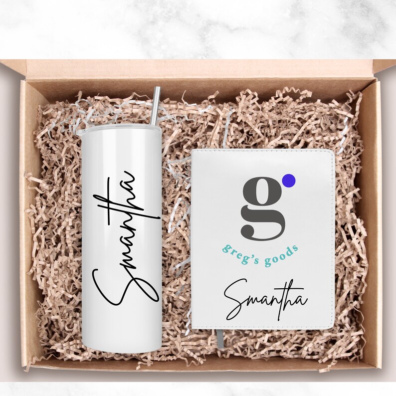 Pode incluir: Um conjunto de presente com um copo branco com o nome Samantha e um caderno branco com o nome Samantha e o logotipo "g" para Greg's Goods.