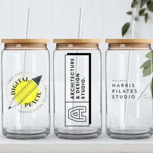 Pode incluir: Tr&ecirc;s copos de vidro transparentes com tampas de bambu e canudos brancos. Os copos t&ecirc;m diferentes logotipos impressos neles: "Digital Pencil Graphic Design Solutions", "Architecture & Design Studio" e "Wellness Harris Pilates Studio".