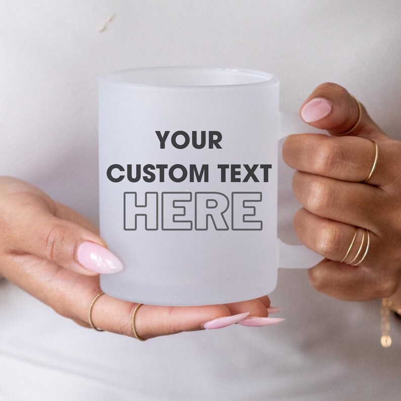 May include: White frosted mug with a black outline of the text "YOUR CUSTOM TEXT HERE" on the front.