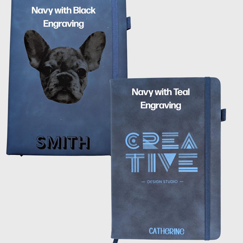 May include: Two navy blue notebooks with elastic closures. The left notebook features a black engraved French bulldog portrait and the name SMITH. The right notebook displays the word CREATIVE, the text DESIGN STUDIO, and the name CATHERINE in teal.