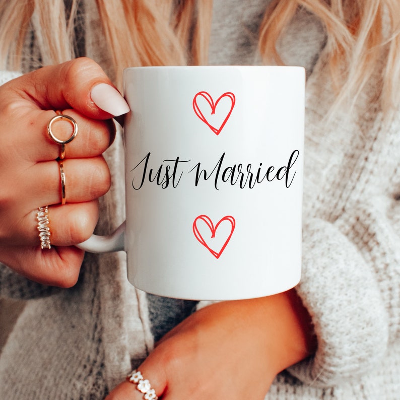 May include: White ceramic mug with the text "Just Married" in black cursive lettering and two red hearts.