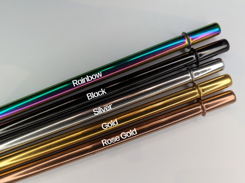 Op de afbeelding: Vijf drinkrietjes van roestvrij staal in verschillende kleuren: regenboog, zwart, zilver, goud en ros&eacute; goud. De rietjes zijn in een rij gerangschikt, met het regenboog rietje bovenaan en het ros&eacute; gouden rietje onderaan.