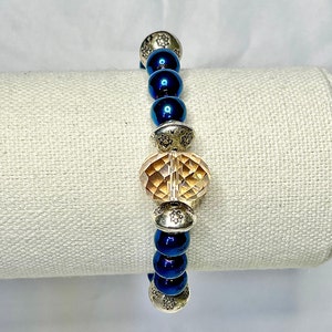 Beautiful deep royal blue bracelet with gold multi faceted  bead is stunning. Stretch band for comfort and easy on and off.