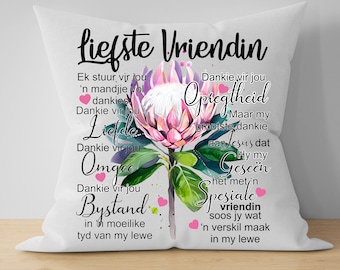May include: A white cushion with a pink and purple protea flower design and text in Dutch that reads "liefste vriendin" and includes the words "dankie vir jou" and "omgee".