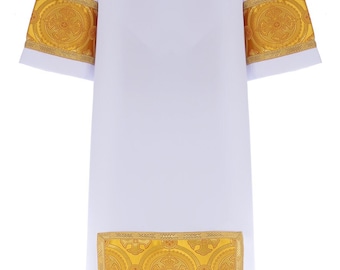 Puede incluir: Ropa litúrgica blanca con ribetes bordados en oro alrededor de los puños y el dobladillo. El ribete presenta un patrón repetido de círculos y cruces.