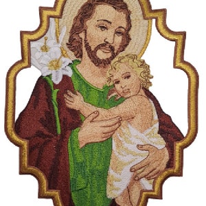 Puede incluir: Parche bordado que representa a San José sosteniendo a un bebé Jesús. El parche está enmarcado en un borde dorado y tiene una flor de lis blanca detrás de San José.