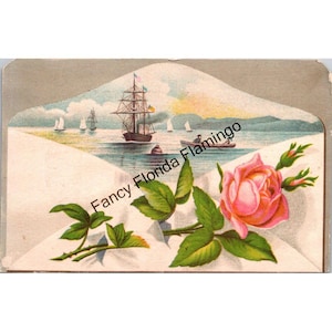 Könnte beinhalten: Vintage-Illustration mit einem Segelschiff auf dem Meer, mit kleineren Segelbooten in der Ferne. Eine rosa Rose mit grünen Blättern und Knospen befindet sich im Vordergrund. Der Text "Fancy Florida Flamingo" ist auf dem Bild aufgedruckt.