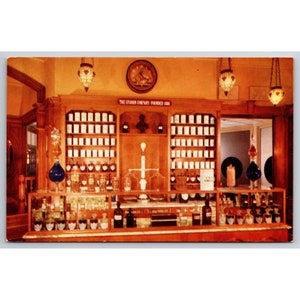 May include: A vintage apothecary shop interior with wooden shelves filled with glass jars and bottles. The shelves are labelled "The Upjohn Company Founded 1886".