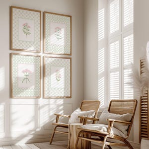 May include: Four framed botanical prints with pink flowers on a white background. The prints are arranged in a grid pattern on a white wall. Two wicker chairs with white cushions are in the foreground.