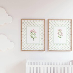 May include: Two framed prints with a white background and a green and gold patterned border. Each print features a pink flower with green leaves.