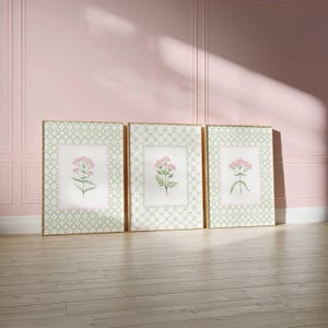 May include: Three framed prints with a green and white geometric pattern. Each print features a pink flower with green leaves on a white background.