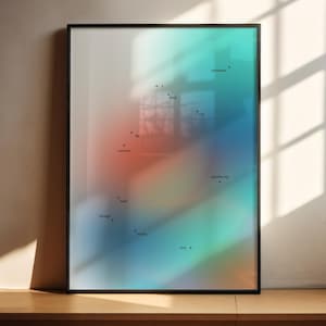 May include: Framed art print with a colorful, abstract design. The artwork features a gradient of colors, including orange, blue, and green, with small text elements and plus signs scattered across the surface. The frame is black, and the print is displayed on a wooden surface.