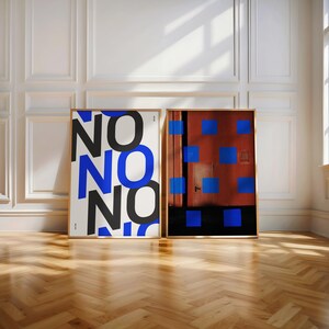Puede incluir: Dos l&aacute;minas art&iacute;sticas enmarcadas. Una l&aacute;mina presenta la palabra "NO" repetida en negro y azul. La otra muestra un fondo rojo con cuadrados azules. Ambas est&aacute;n en marcos de madera, sobre una pared blanca y suelo de madera.