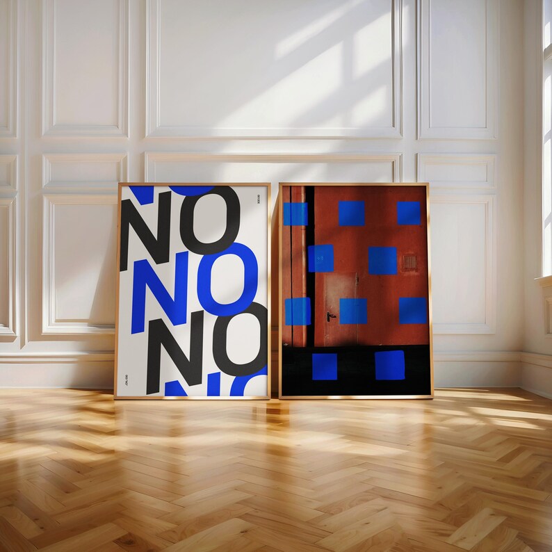 Puede incluir: Dos l&aacute;minas art&iacute;sticas enmarcadas. Una l&aacute;mina presenta la palabra "NO" repetida en negro y azul. La otra muestra un fondo rojo con cuadrados azules. Ambas est&aacute;n en marcos de madera, sobre una pared blanca y suelo de madera.