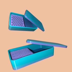 May include: Two turquoise plastic containers with purple lids and a purple grid inside. The containers are open and the lids are off.