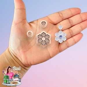 May include: A set of four light peach-colored polymer clay cutters featuring a large six-petaled flower shape, a small triangular shape, a circular shape, and a finished white flower-shaped pendant with a central blue stone.