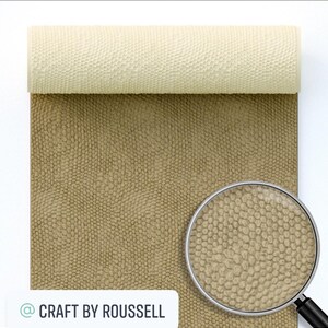 May include: A roll of beige faux leather with a textured, embossed pattern resembling reptile skin. A magnifying glass shows a close-up of the texture. The text "@ CRAFT BY ROUSSELL" is visible in the lower left corner.
