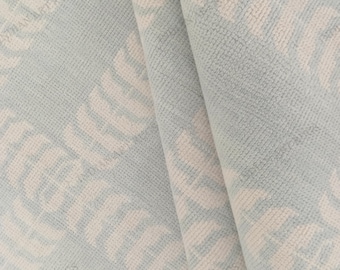 May include: A light blue and cream textile featuring a repeating leaf-like pattern. The fabric has a soft, textured surface with a visible weave. The design consists of stylized, curved botanical shapes arranged in diagonal rows across the material.