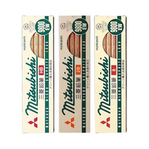 May include: Three rectangular boxes of Mitsubishi 9800 EW recycled pencils, each featuring a circular cutout revealing the pencils inside. The boxes are labeled with HB, 2B, and B lead grades, displaying the Mitsubishi logo and text in English and Japanese.