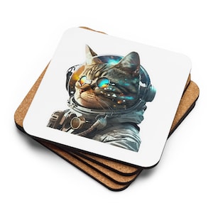 Puede incluir: Un juego de cuatro posavasos blancos con un gato que lleva un casco de astronauta y gafas de sol. Los ojos del gato son azules y verdes, y el casco tiene un diseño de galaxia. Los posavasos están hechos de corcho y tienen un fondo blanco.