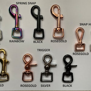 May include: Assortment of metal spring snap and snap hook clasps in silver, gold, rose gold, rainbow, and black finishes. The clasps are arranged in two rows with the text "SPRING SNAP" and "SNAP HOOK" above the rows.