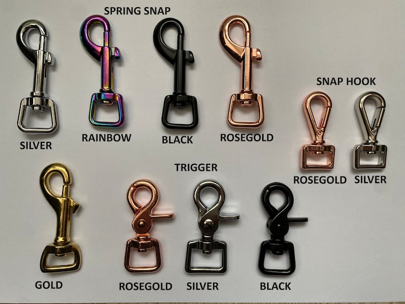 May include: Assortment of metal spring snap and snap hook clasps in silver, gold, rose gold, rainbow, and black finishes. The clasps are arranged in two rows with the text "SPRING SNAP" and "SNAP HOOK" above the rows.
