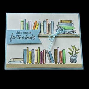 Cette carte amusante faite main est parfaite pour les amateurs de lecture ! Des couleurs vives, des étagères pleines et un thème de lecture joyeux qu'ils apprécieront !