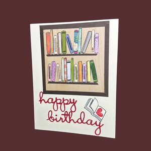 Carte de joyeux anniversaire avec des livres colorés sur des étagères — Une carte amusante pour les lecteurs qui aiment faire la fête