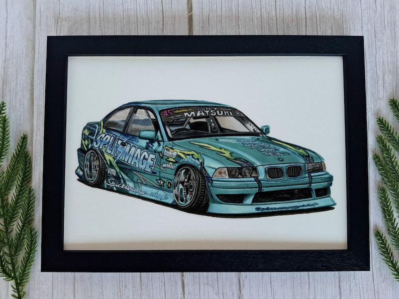 May include: A framed illustration of a light blue drift car featuring yellow flame graphics, the text SPLITMAGE on the side, and MATSURI on the windshield. The car has a lowered stance, wide wheels, and a front bumper with a black grille and headlights.