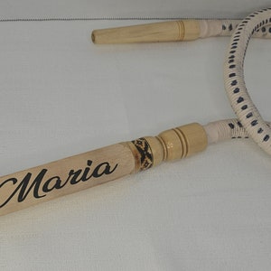 May include: A white and black hookah hose with a wooden mouthpiece that says "Maria" on it.