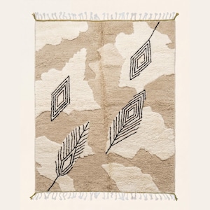 Op de afbeelding: Rechthoekig beige tapijt met een crèmekleurig wolkenpatroon en zwarte geometrische diamant- en veervormige ontwerpen. Het tapijt heeft franjes aan de korte uiteinden. Ideaal voor een woonkamer of slaapkamer.
