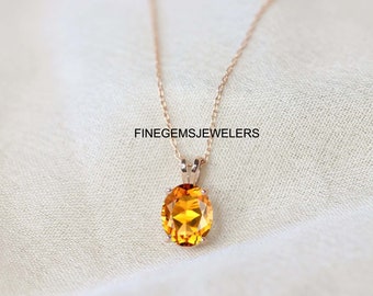Puede incluir: Un collar de cadena de oro con un colgante redondo de piedra preciosa naranja. El colgante está engastado en un engaste de oro y tiene un acabado pulido. FINEGEMSJewelers está impreso en el fondo blanco.