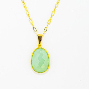 May include: A gold chain necklace with a light green oval pendant.