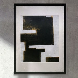 Puede incluir: Pintura abstracta en un marco negro. La pintura presenta un fondo blanco con formas geométricas negras y doradas.